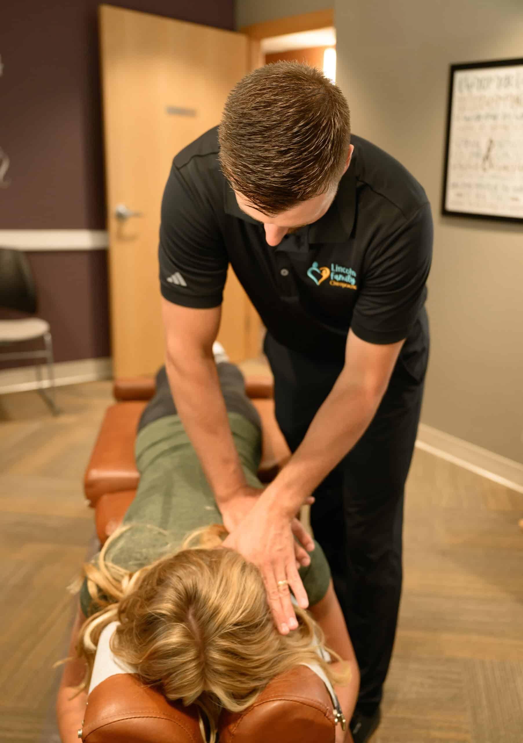 Chiropractic treatment session at Lincoln Family Chiropractic, focusing on spinal adjustments to promote health and wellness. A chiropractor performs a gentle manipulation on a patient lying on a chiropractic table.