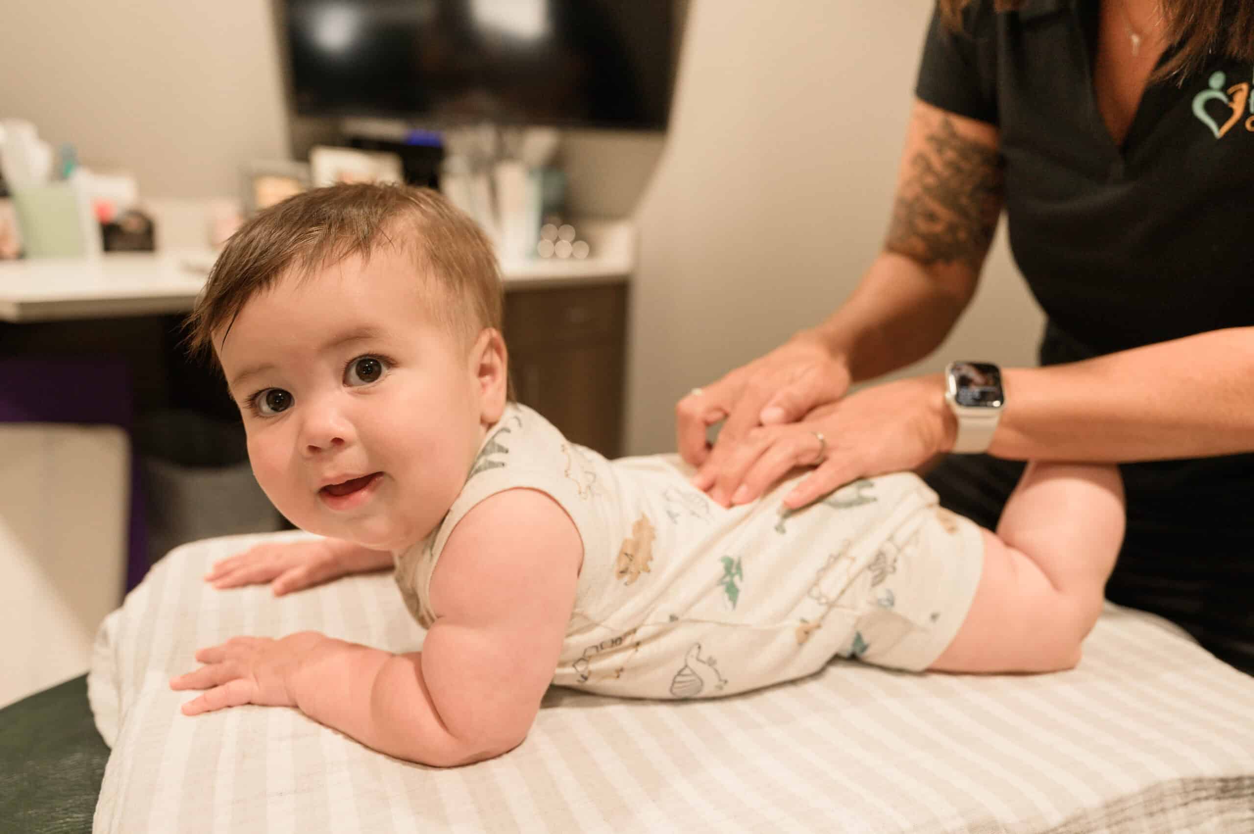 Gentle chiropractic adjustment on a smiling baby at Lincoln Family Chiropractic, promoting pediatric health and wellness through safe, caring chiropractic care for infants and children.